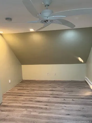 a view of a room with a ceiling fan and wooden floor