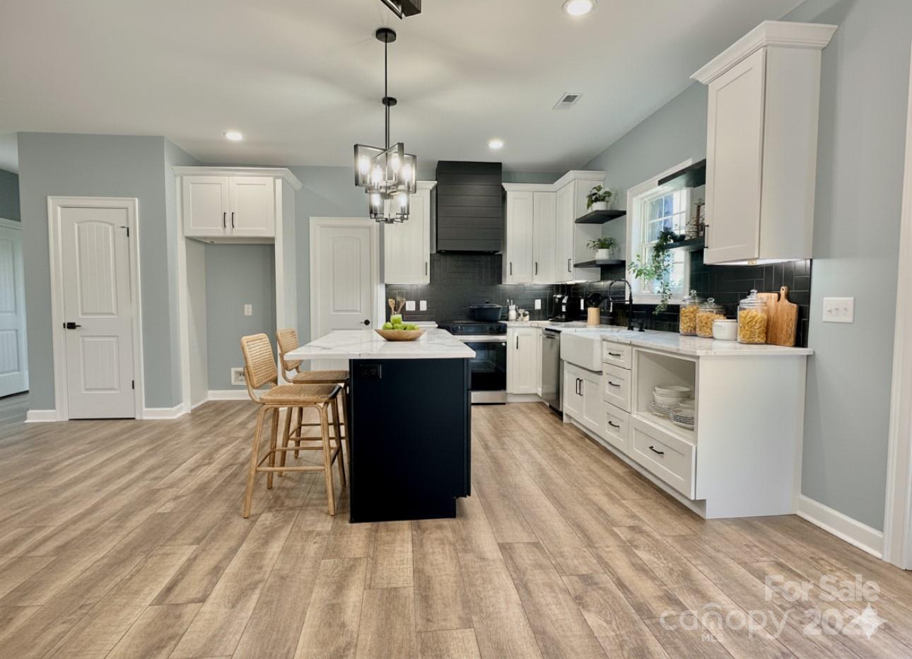 2667 Polo Lane Maiden, NC 28650 - Photo 23 of 36 a large kitchen with stainless steel appliances kitchen island granite countertop a stove a sink dishwasher and a refrigerator with wooden floor