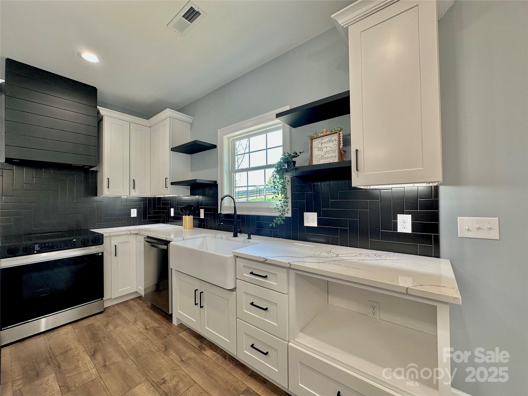 2667 Polo Lane Maiden, NC 28650 - Photo 24 of 36 a kitchen with stainless steel appliances granite countertop a sink a stove a microwave a sink and cabinets