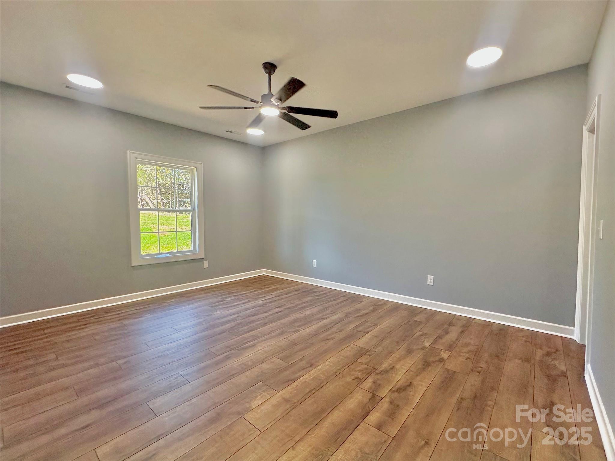 2667 Polo Lane Maiden, NC 28650 - Photo 34 of 36 an empty room with wooden floor fan and windows