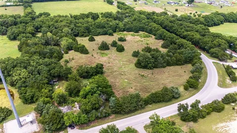 an aerial view of a house with a yard and lake