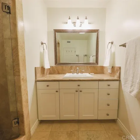 a bathroom with a granite countertop sink and a mirror