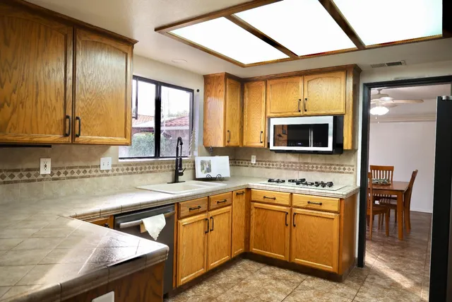 a kitchen with granite countertop cabinets stainless steel appliances and a window