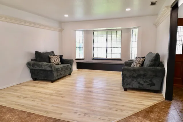 a living room with furniture window and wooden floor