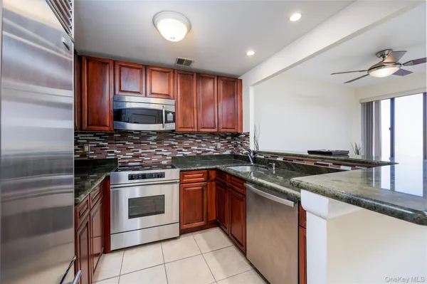 a kitchen with stainless steel appliances granite countertop a sink stove and cabinets