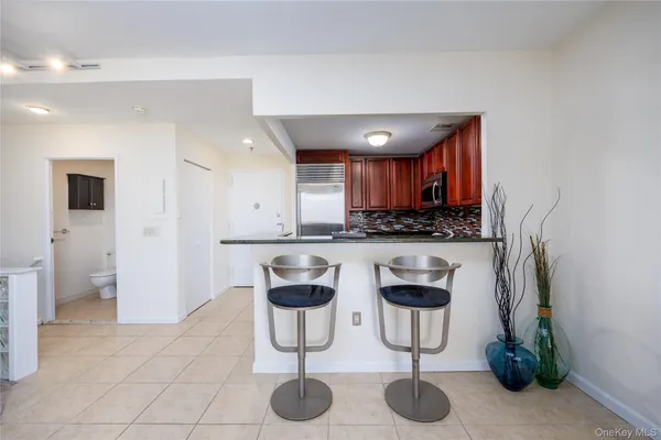 a kitchen with stainless steel appliances granite countertop a refrigerator a stove a sink and a counter space