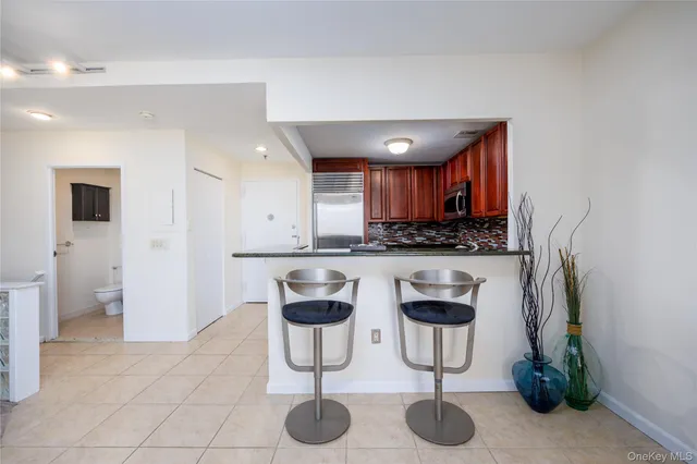 a kitchen with stainless steel appliances granite countertop a refrigerator a stove a sink and a counter space