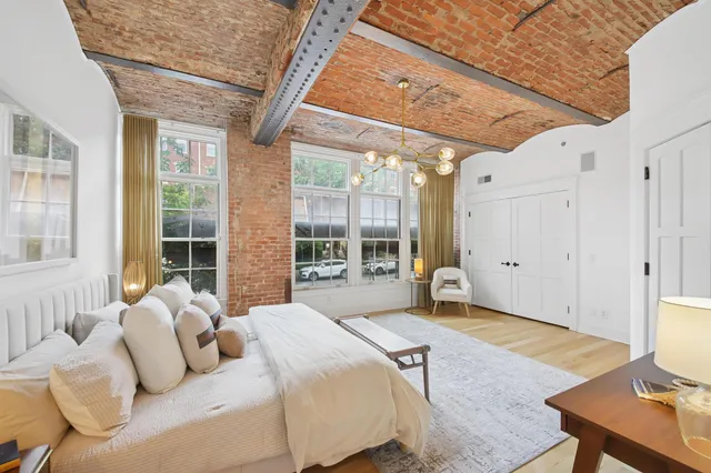 a bedroom with a bed and large windows