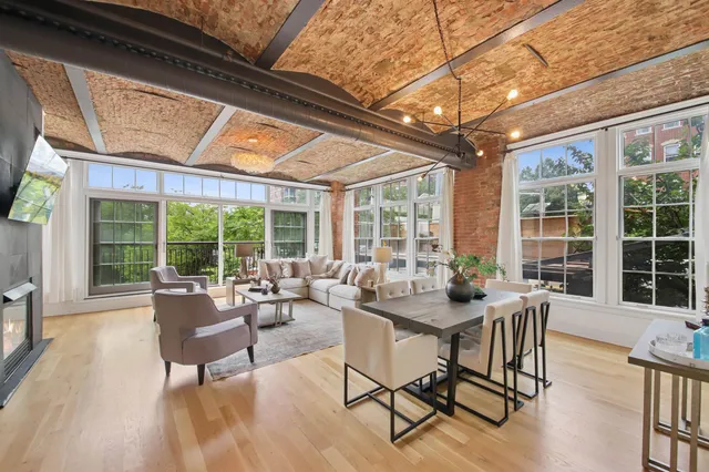 a dining room with furniture large windows and wooden floor