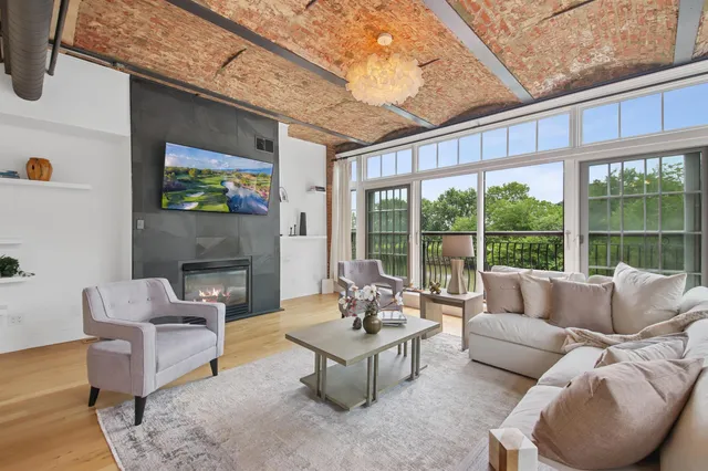 a living room with furniture a flat screen tv and a fireplace
