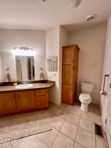 a large bathroom with a toilet a sink and a mirror