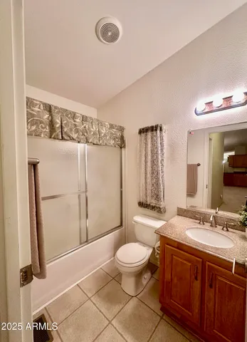a spacious bathroom with a double vanity sink a toilet a mirror and shower