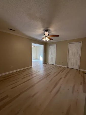 a view of an empty room with wooden floor
