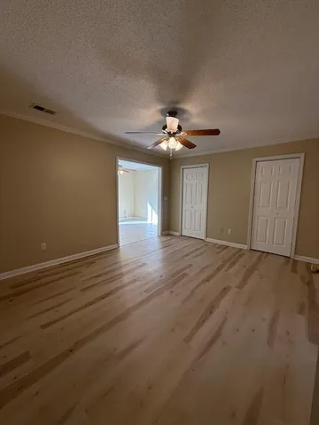 a view of an empty room with wooden floor