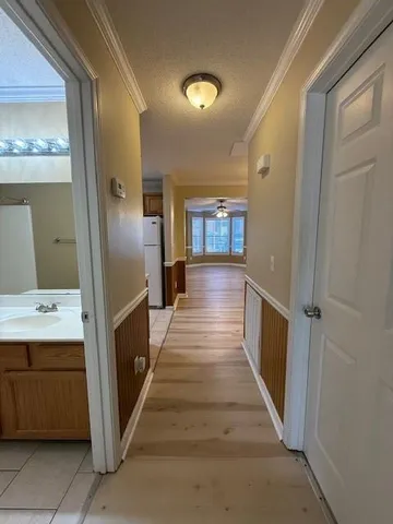 a view of a hallway with wooden floor and staircase