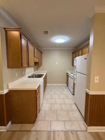 a kitchen with a sink a refrigerator and a stove top oven