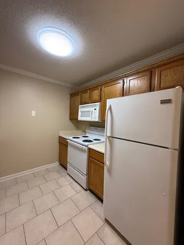 a white refrigerator freezer and a stove sitting inside of a kitchen