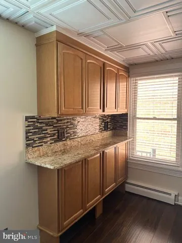 a bathroom with a granite countertop sink and a window