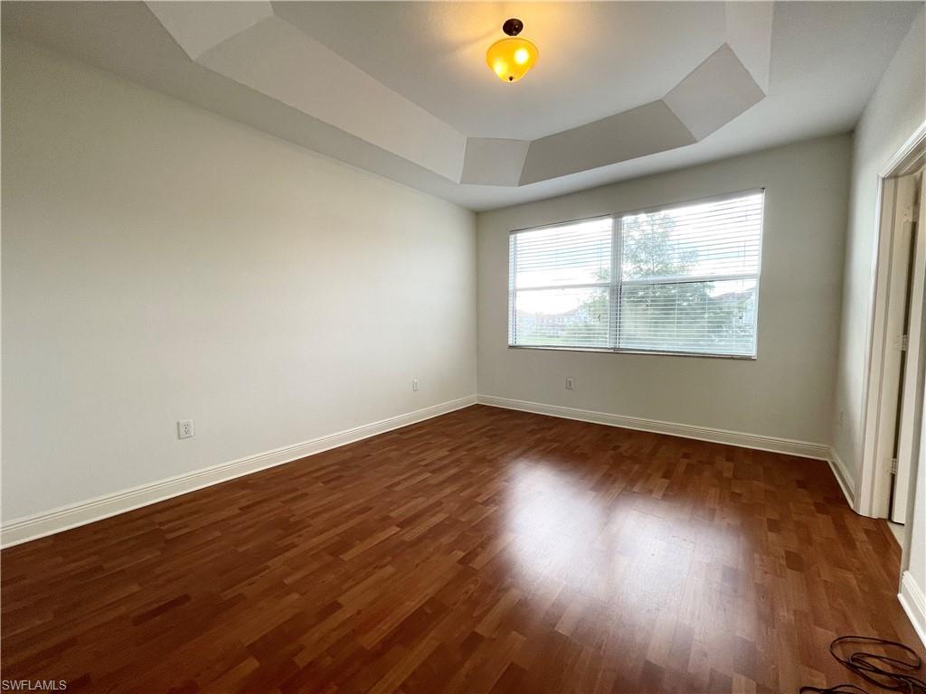 7051 Ambrosia Lane, Unit 3506 Naples, FL 34119 - Photo 11 of 23 an empty room with wooden floor and windows
