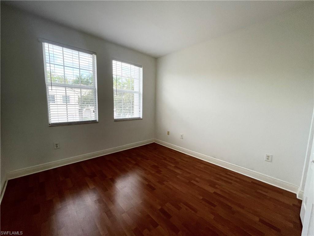 7051 Ambrosia Lane, Unit 3506 Naples, FL 34119 - Photo 12 of 23 an empty room with wooden floor and windows