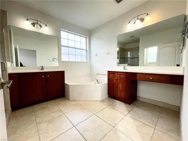 a bathroom with a bathtub sink vanity and mirror
