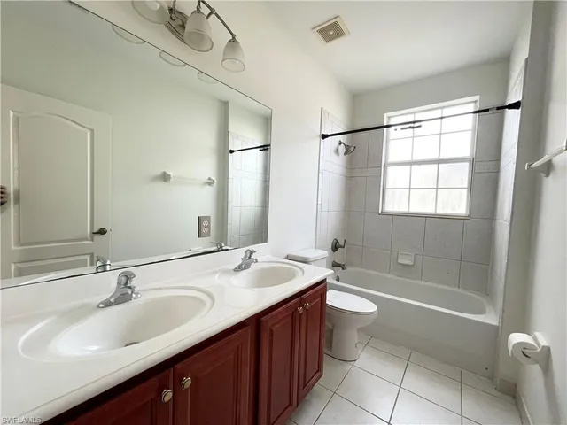 a bathroom with a double vanity sink toilet mirror and shower