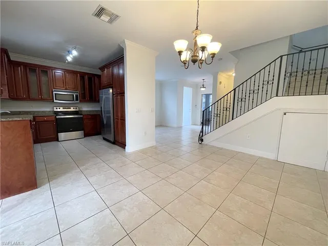 a open kitchen with kitchen island granite countertop a refrigerator a stove top oven and a sink