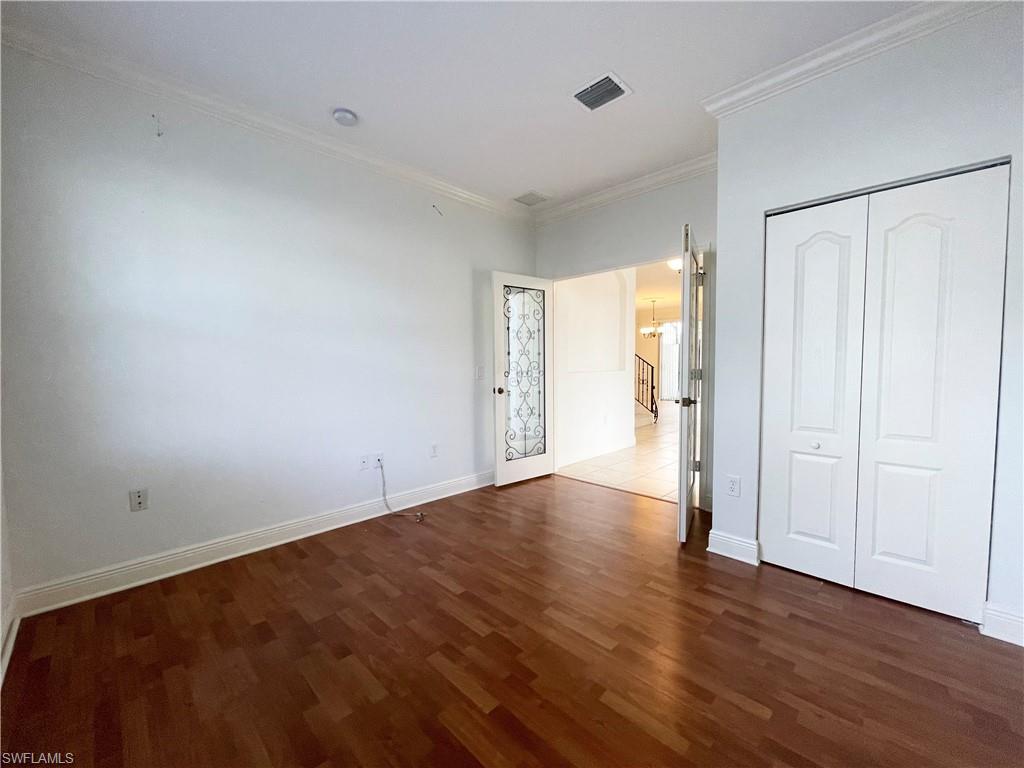 7051 Ambrosia Lane, Unit 3506 Naples, FL 34119 - Photo 10 of 23 a view of an empty room with wooden floor and a window