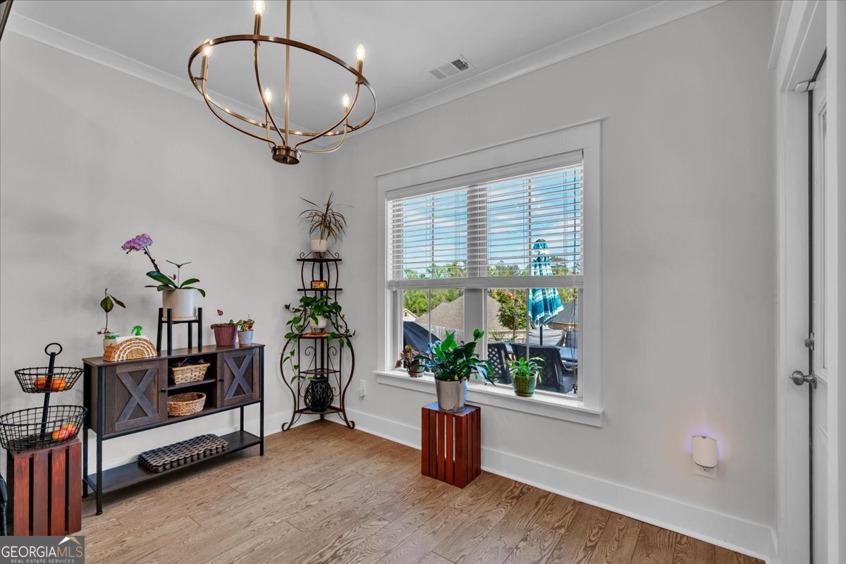 424 Rustic Live Oak Trail Bonaire, GA 31005 - Photo 15 of 51 a view of a room with wooden floor windows and a chandelier