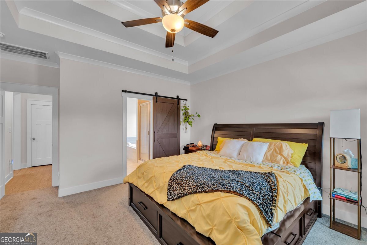 424 Rustic Live Oak Trail Bonaire, GA 31005 - Photo 20 of 51 a bedroom with a large bed and a chandelier