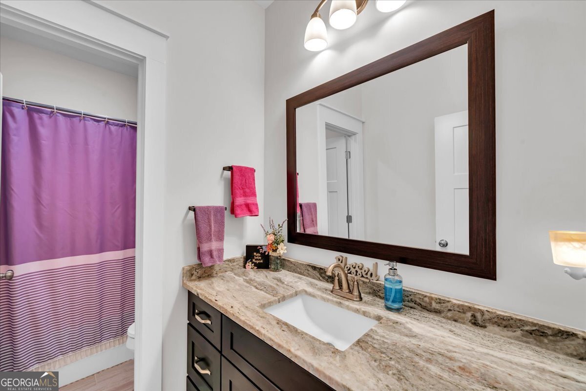424 Rustic Live Oak Trail Bonaire, GA 31005 - Photo 29 of 51 a bathroom with a granite countertop sink and a mirror
