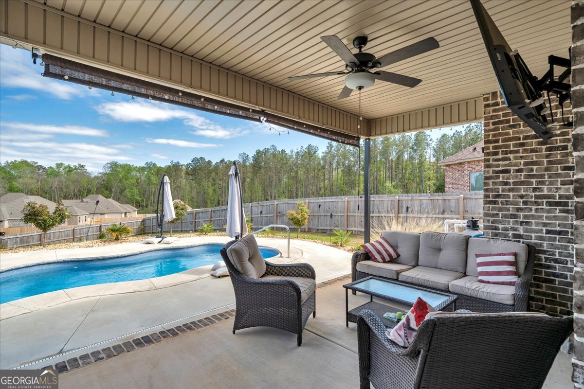 424 Rustic Live Oak Trail Bonaire, GA 31005 - Photo 36 of 51 a living room with patio furniture and a floor to ceiling window