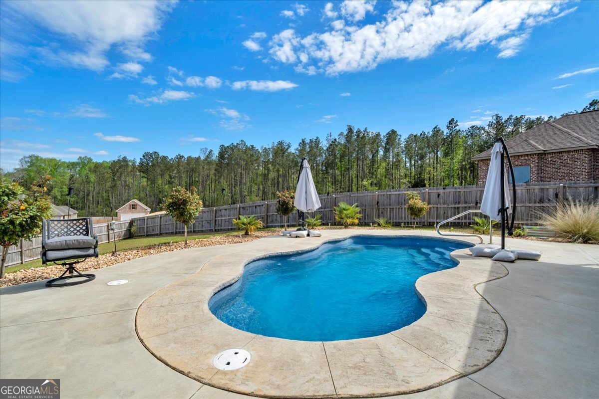 424 Rustic Live Oak Trail Bonaire, GA 31005 - Photo 51 of 51 a view of a swimming pool with a patio and a garden