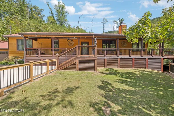a view of a house with backyard and deck