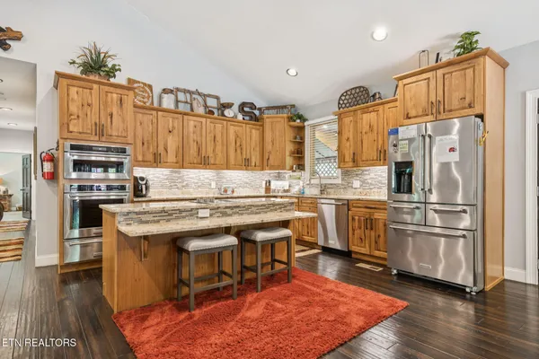 a kitchen with granite countertop a sink dishwasher stove and cabinets