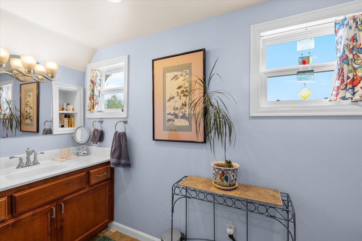 440 Bush Street Central Point, OR 97502 - Photo 22 of 40 a bathroom with a sink a mirror and painting on the wall