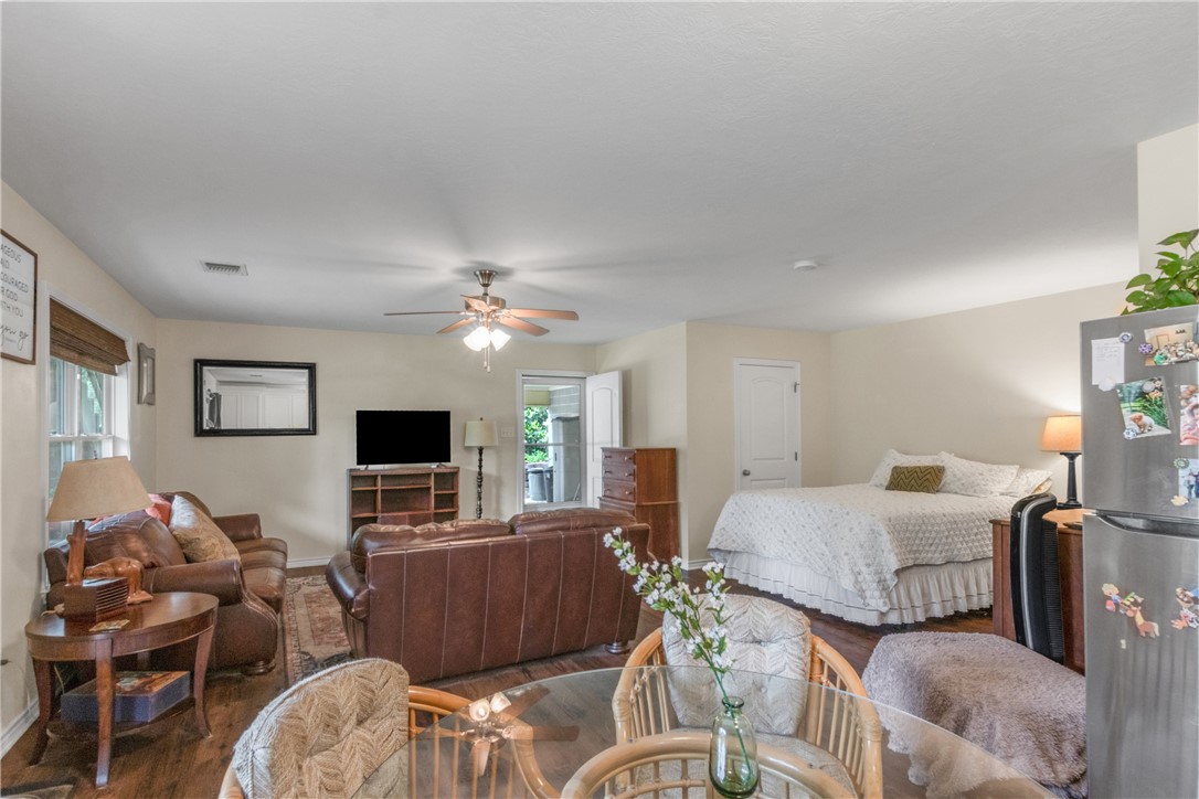 9997 Calhoun Road Bryan, TX 77808 - Photo 47 of 50 a bedroom with furniture a flat screen tv and a fireplace