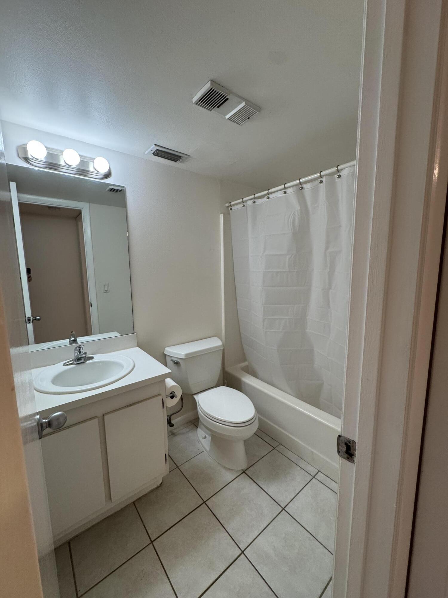 21890 Lake Forest Circle, Unit 102 Boca Raton, FL 33433 - Photo 11 of 24 a bathroom with a sink a toilet and shower