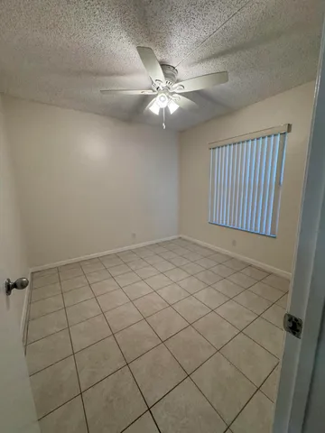 en empty room with windows and ceiling fan