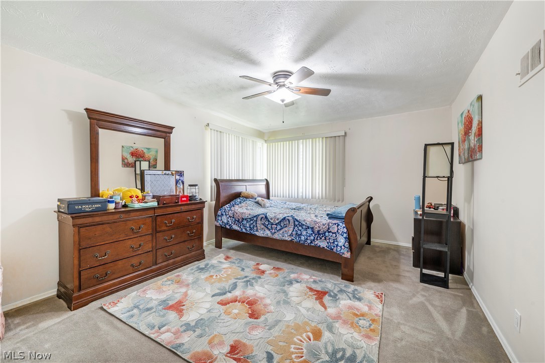 6597 York Road Parma Heights, OH 44130 - Photo 20 of 34 Bedroom with ceiling fan, light colored carpet, and a textured ceiling