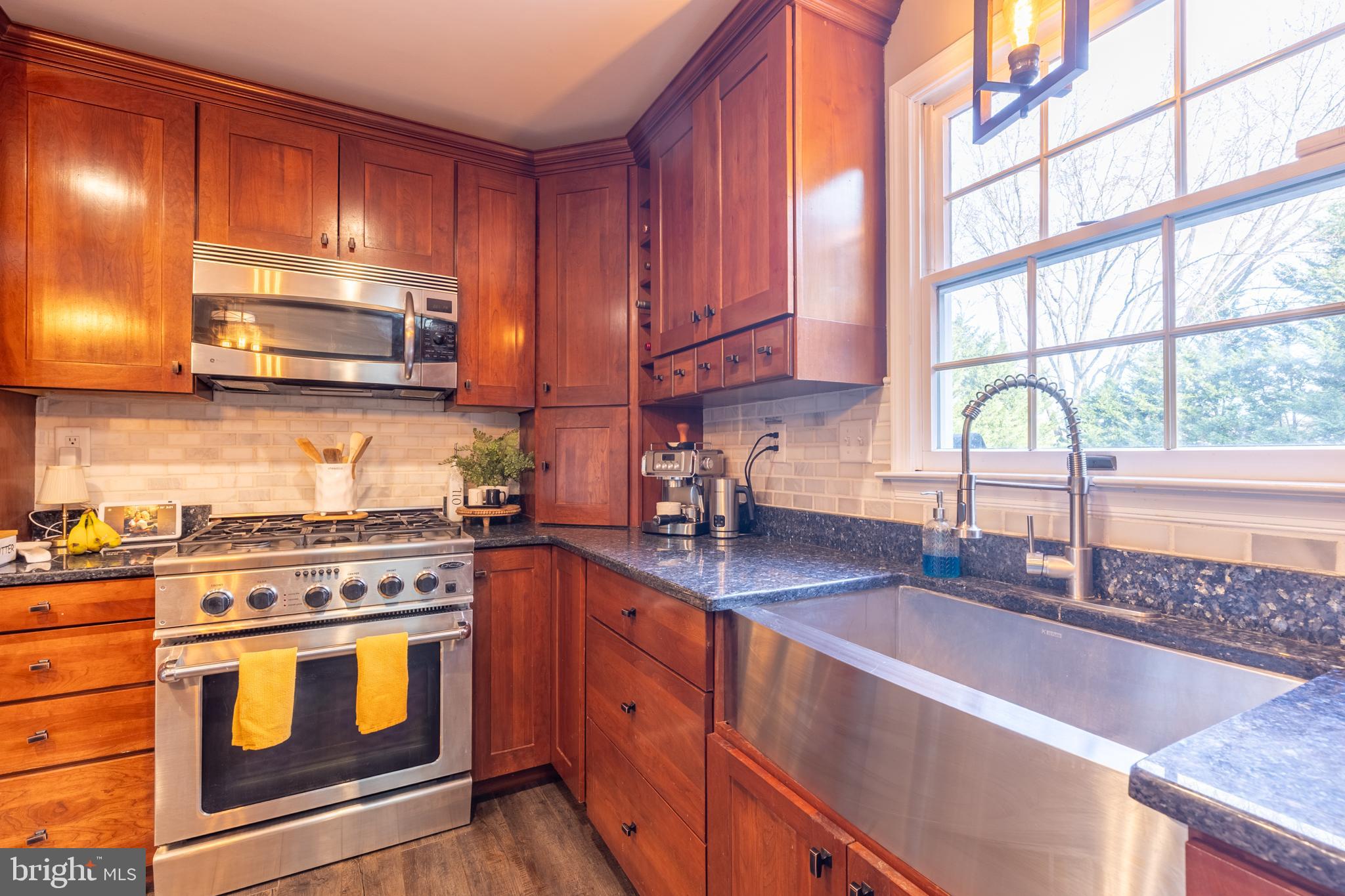 3 Heatherstone Way Hockessin, DE 19707 - Photo 7 of 29 a kitchen with stainless steel appliances granite countertop wooden cabinets stove top oven and sink