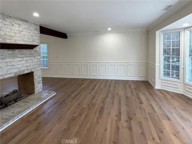 an empty room with wooden floor and fireplace