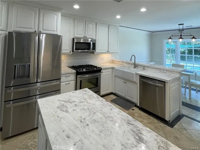 a kitchen with stainless steel appliances granite countertop a sink stove and refrigerator