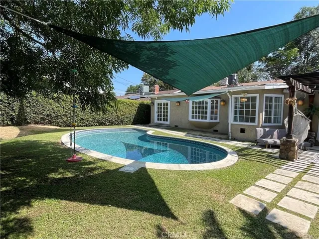 a view of a house with swimming pool and a yard