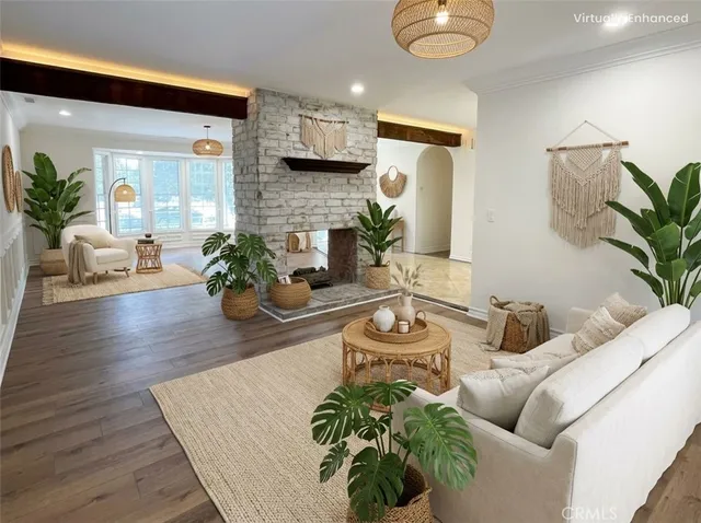 a living room with furniture potted plant and a wooden floor