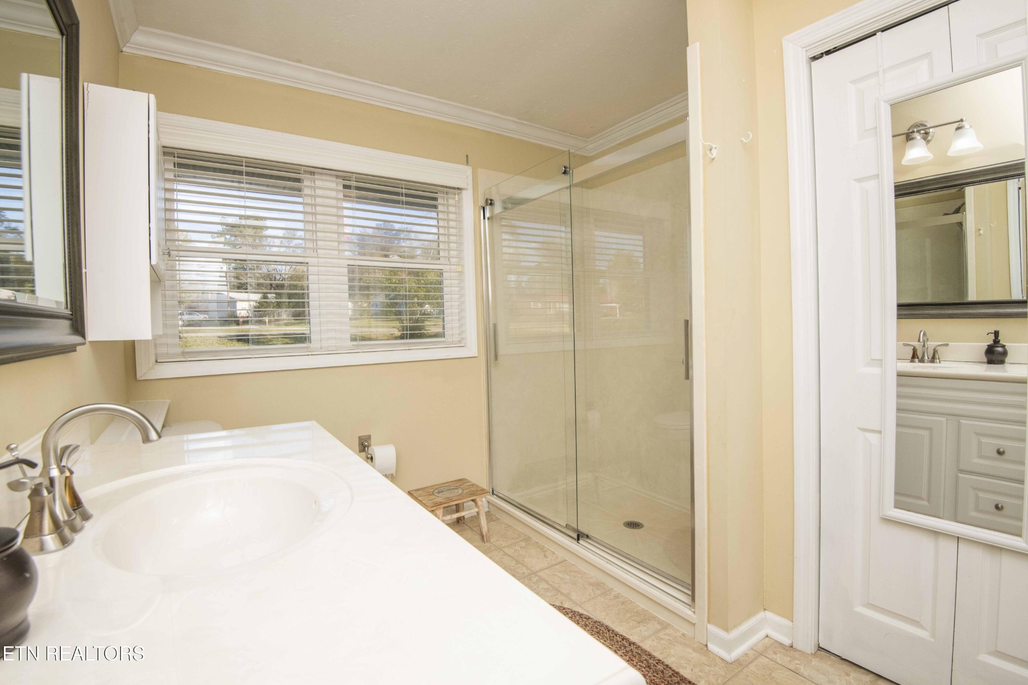 651 Hines Valley Road Lenoir City, TN 37771 - Photo 19 of 44 a bathroom with a granite countertop sink a mirror and a shower