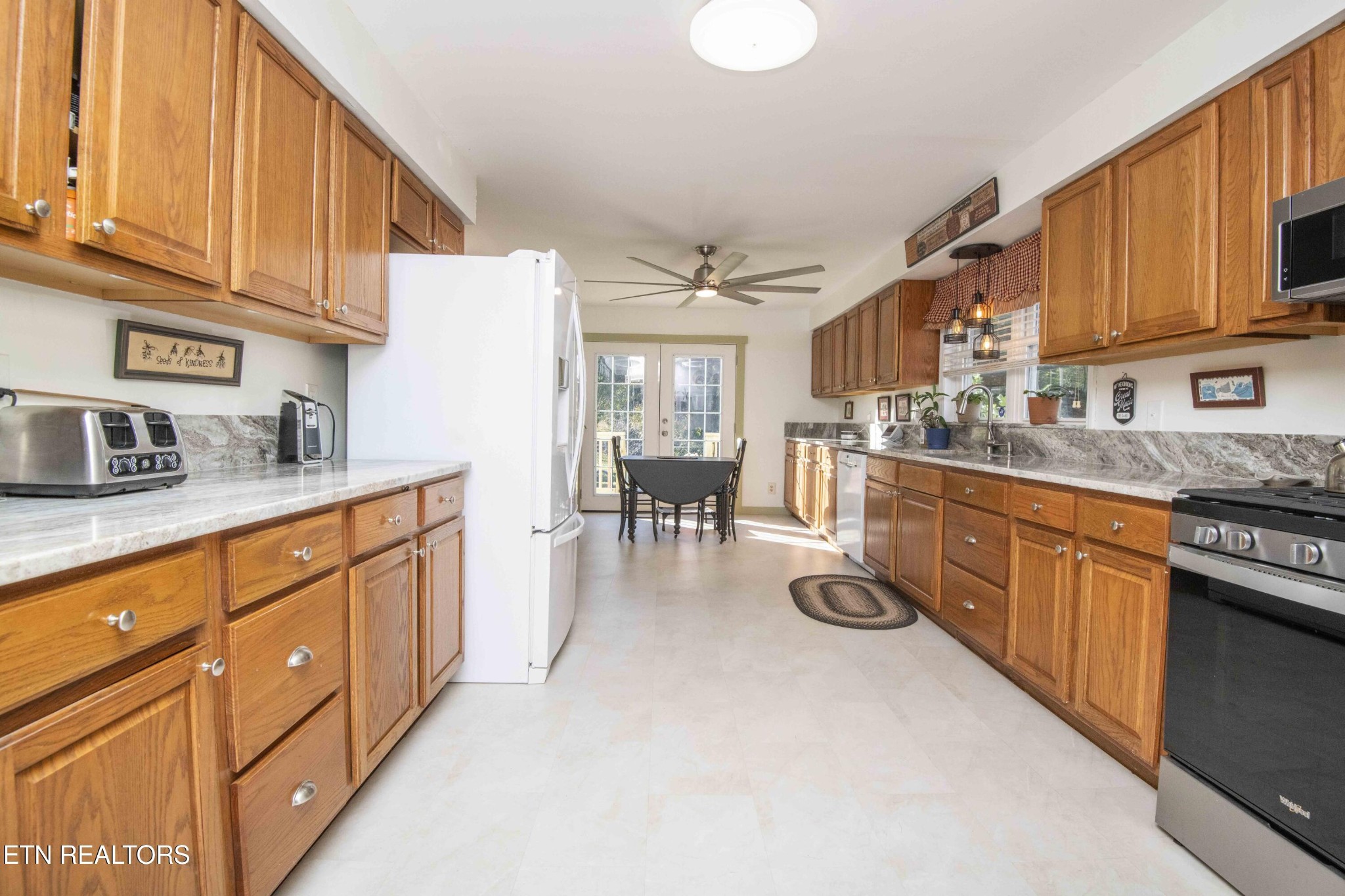 651 Hines Valley Road Lenoir City, TN 37771 - Photo 3 of 44 a kitchen with stainless steel appliances granite countertop a sink dishwasher stove and refrigerator with wooden cabinets