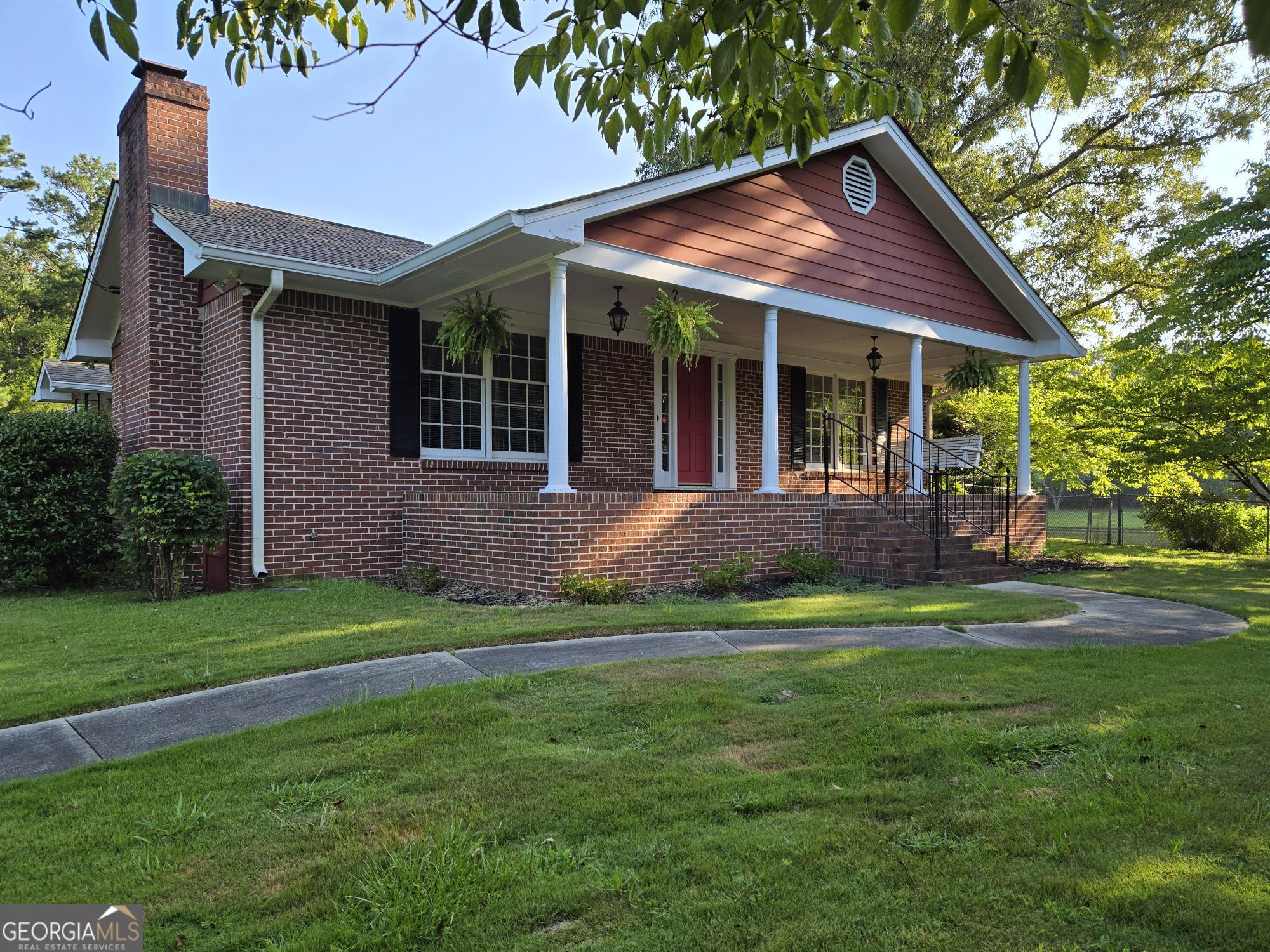 a front view of a house with a garden