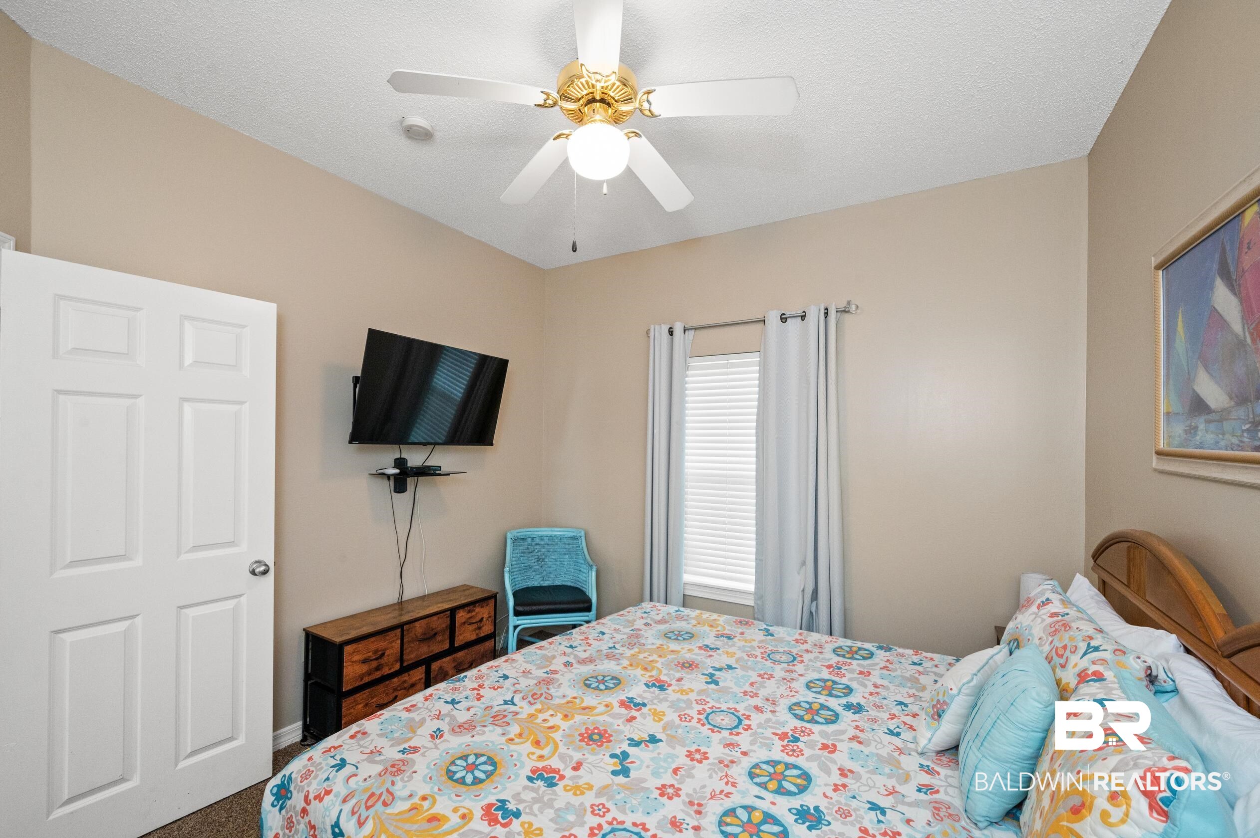 1380 Fort Morgan Road, Unit 106 Gulf Shores, AL 36542 - Photo 8 of 20 Carpeted bedroom with a textured ceiling and ceiling fan