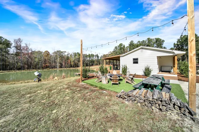 a view of a house with backyard and sitting area